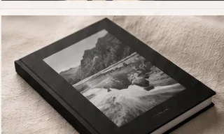 Black clothbound photo book with a black-and-white cover image